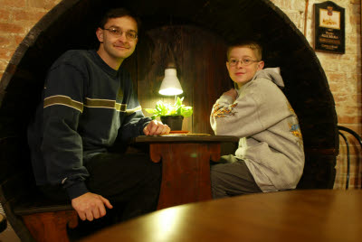Alex and Mark sit in a wine barrel