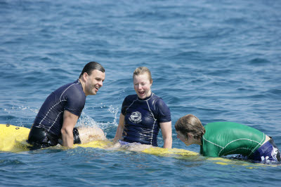 K.C., Lisa, and Alex posing on a Surfboard