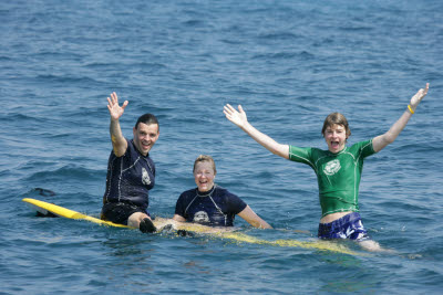 K.C., Lisa, and Alex posing on a Surfboard