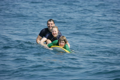 K.C., Lisa, and Alex posing on a Surfboard