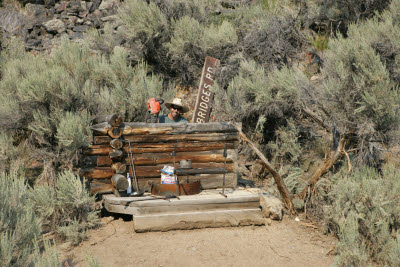 J.B. in the outhouse with chainsaw